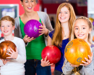 Kid's holding bowling balls smiling