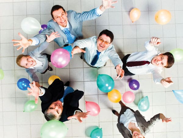 Party_Corporate Corporate workers tossing balloons in the air